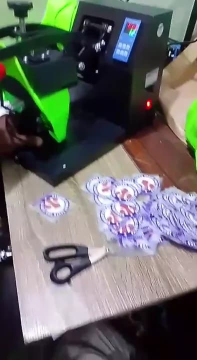 Stacks of die-cut circular campaign transfer badges arranged beside neon green baseball caps on a workshop table.