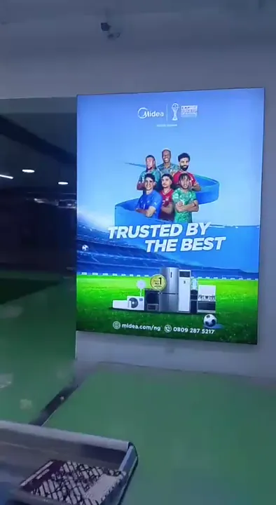 Illuminated Midea backlit tension fabric lightbox mounted on a showroom wall in Lagos.