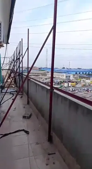 Welded steel rooftop signage structure with diagonal braces overlooking a Lagos streetscape.