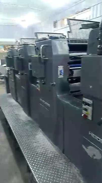 Sheet-fed offset printing press rapidly outputting full-colour campaign posters onto delivery stack.