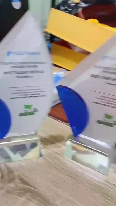 Three flame-shaped crystal glass award trophies with blue accents and printed citations for NOLT Finance.
