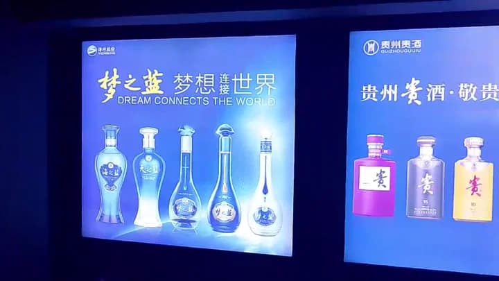 Glowing blue Yanghe and Guizhou Guijiu frameless backlit fabric lightboxes mounted side by side.