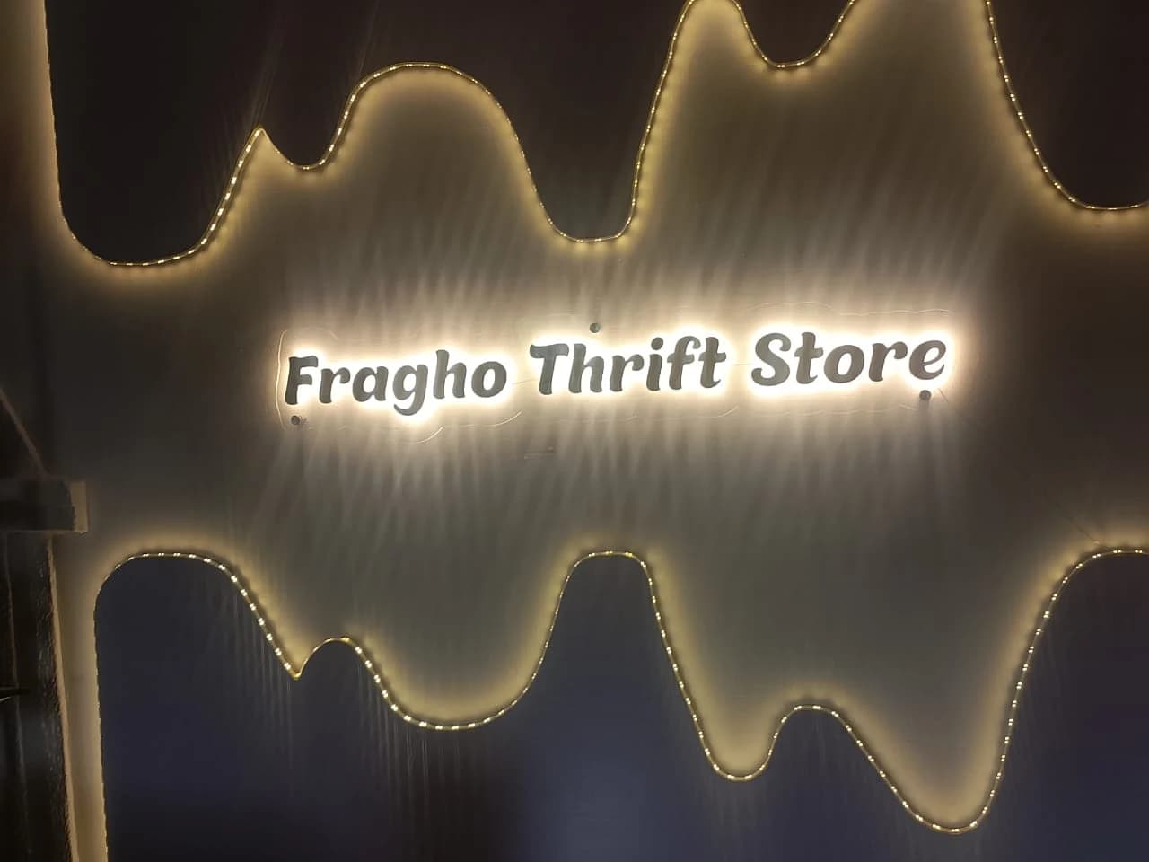 Fragho Thrift Store halo-illuminated letters mounted within an organic undulating LED glowing wall contour.